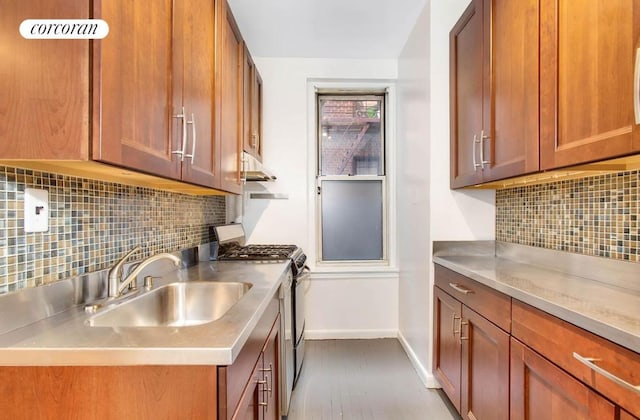 kitchen with sink, backsplash, stainless steel gas range, and wood-type flooring