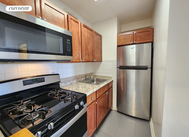 kitchen with stainless steel appliances, sink, decorative backsplash, and light tile patterned floors