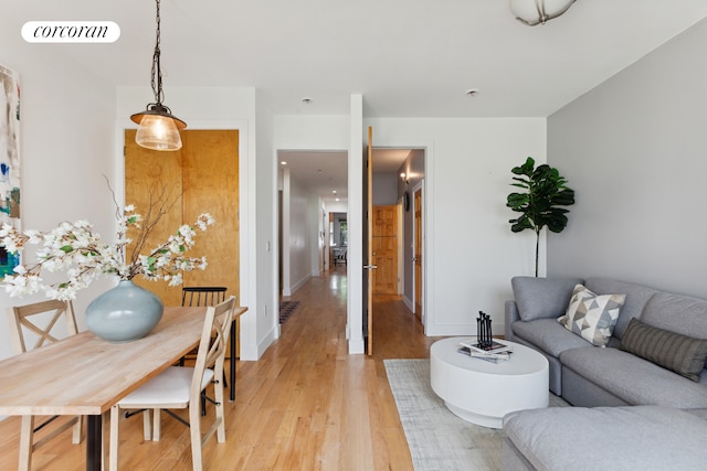 living room with light wood-style flooring, visible vents, and baseboards