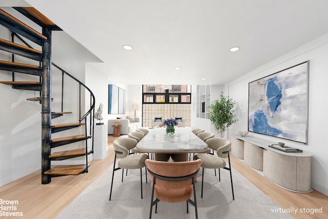 dining room featuring a tile fireplace, recessed lighting, baseboards, stairway, and light wood finished floors