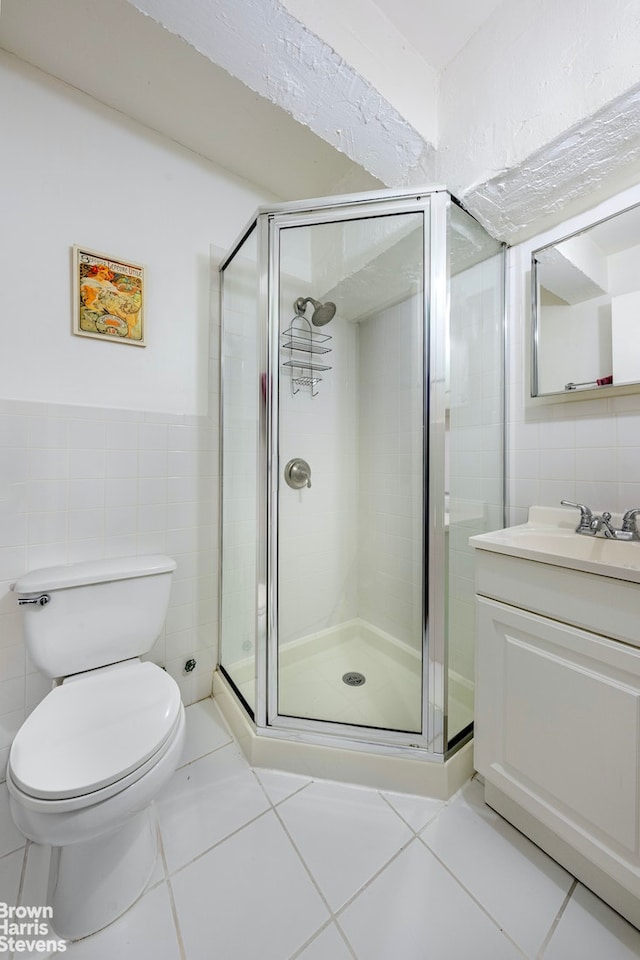 full bathroom with tile patterned floors, vanity, tile walls, and a shower stall