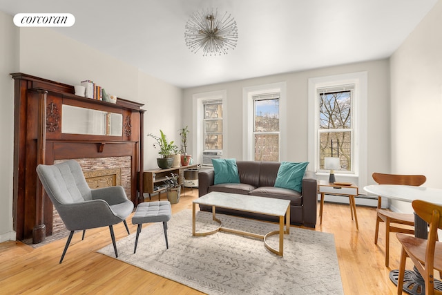 sitting room featuring a baseboard radiator, light wood-style floors, and visible vents