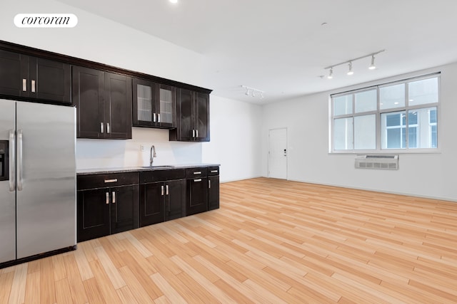 kitchen featuring sink, dark brown cabinets, stainless steel refrigerator with ice dispenser, a wall mounted air conditioner, and light wood-type flooring