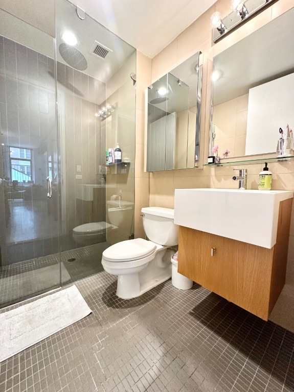 full bathroom featuring toilet, vanity, and bath / shower combo with glass door