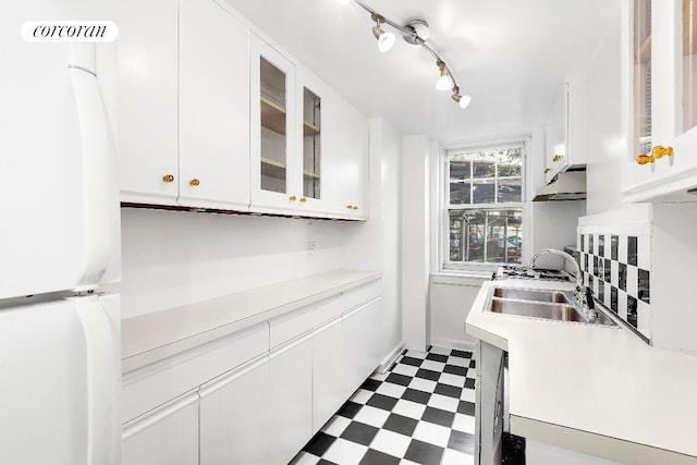 kitchen with white cabinetry, white refrigerator, and sink