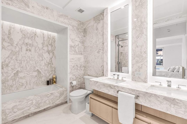 bathroom featuring vanity, tile walls, and toilet