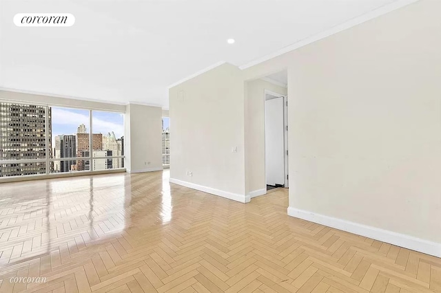 unfurnished room featuring visible vents, a view of city, baseboards, and ornamental molding