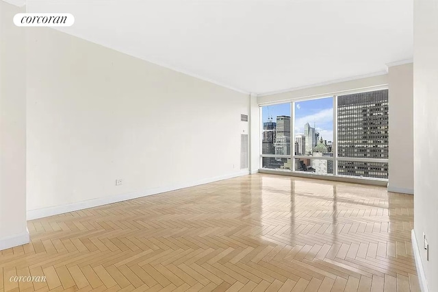 unfurnished room with a city view, baseboards, crown molding, and visible vents