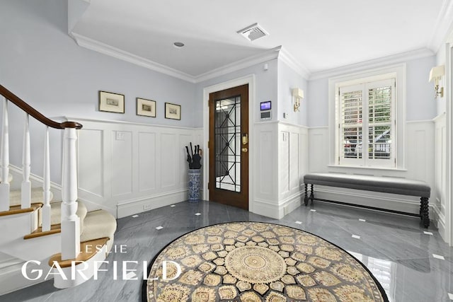 foyer featuring visible vents, a wainscoted wall, marble finish floor, stairs, and a decorative wall