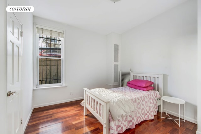 bedroom with hardwood / wood-style flooring and baseboards