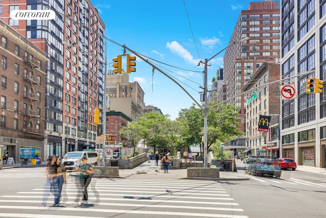 view of road with traffic lights, curbs, sidewalks, and street lights