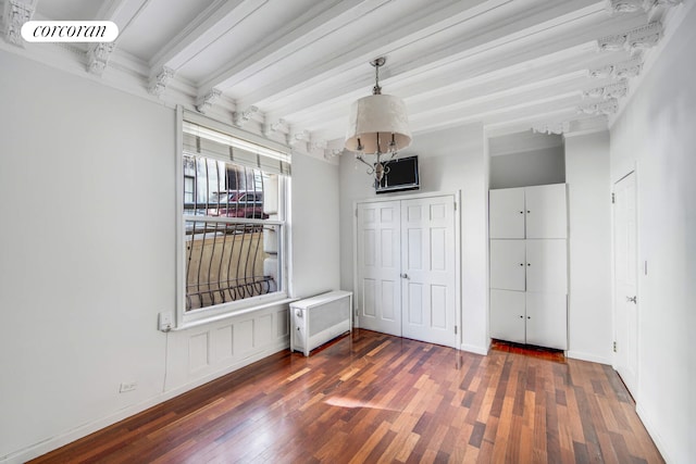 interior space featuring ornamental molding, beamed ceiling, hardwood / wood-style flooring, and baseboards