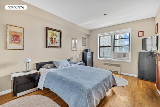 72-11 110th St Unit 3B, New York City, NY 11375 - bedroom with radiator heating unit, light wood-style floors, baseboards, and cooling unit