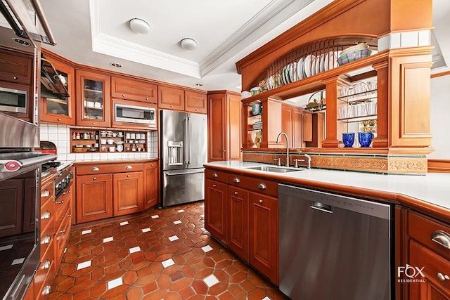 kitchen with sink, crown molding, a tray ceiling, stainless steel appliances, and backsplash