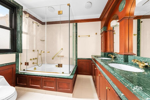 full bathroom with combined bath / shower with glass door, vanity, toilet, crown molding, and tile patterned floors