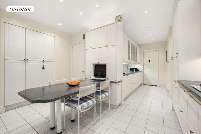 kitchen with white cabinetry, a breakfast bar, and light tile patterned flooring