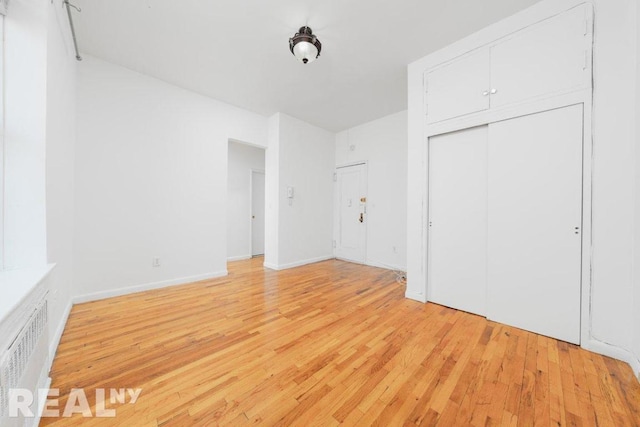 unfurnished bedroom featuring light wood-type flooring and a closet