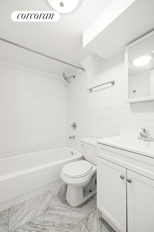 full bathroom with tiled shower / bath combo, vanity, backsplash, tile walls, and toilet