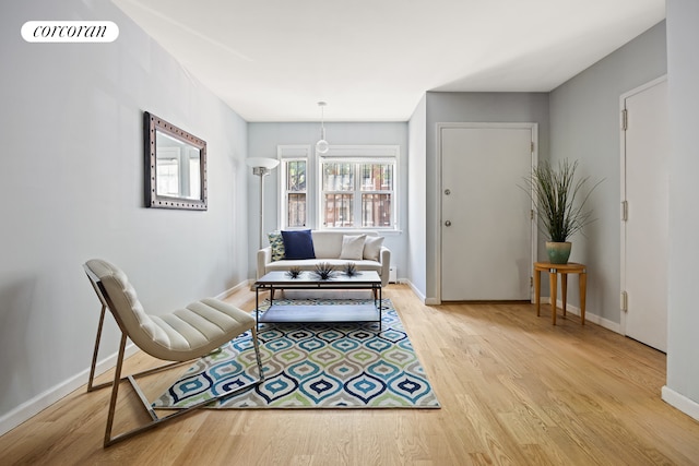 living area with visible vents, light wood-type flooring, and baseboards