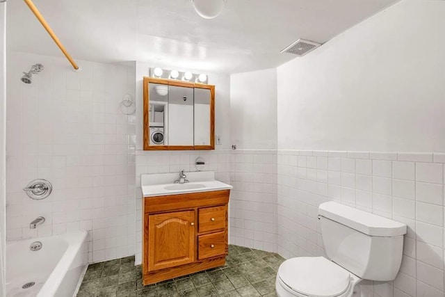 full bathroom with tile walls, vanity, shower / bathtub combination, and toilet