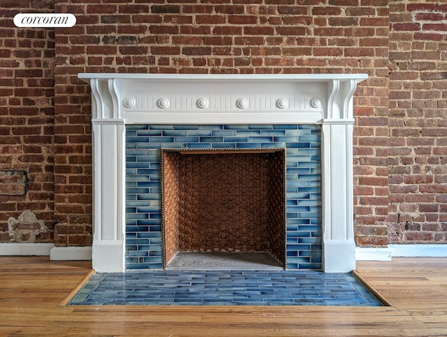54 W 71st Street Building, New York City, NY 10023 - detailed view of wood finished floors, brick wall, baseboards, and a fireplace with flush hearth