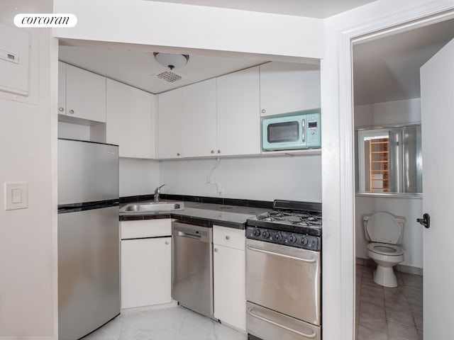 54 W 71st Street Building, New York City, NY 10023 - kitchen with stainless steel appliances, a sink, white cabinets, and dark countertops