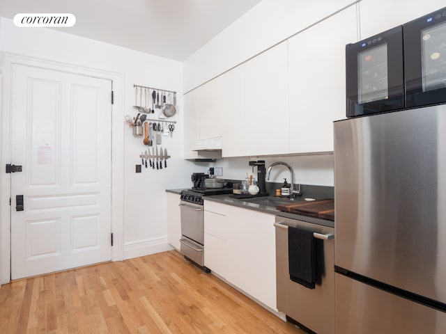 54 W 71st Street Building, New York City, NY 10023 - kitchen with a sink, stainless steel appliances, dark countertops, white cabinetry, and modern cabinets