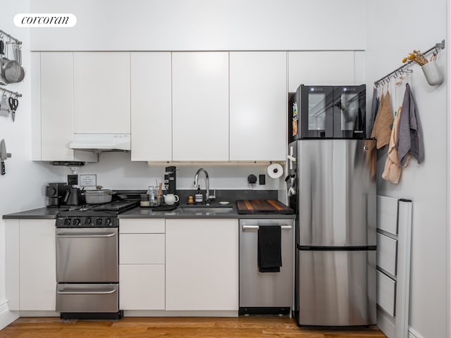 54 W 71st Street Building, New York City, NY 10023 - kitchen with stainless steel appliances, a sink, exhaust hood, and dark countertops