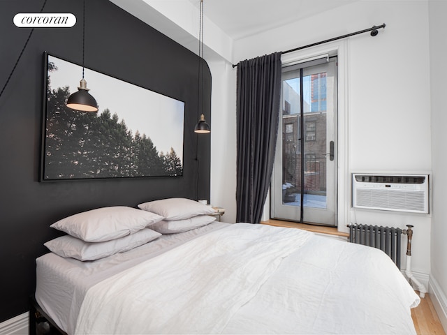 54 W 71st Street Building, New York City, NY 10023 - bedroom with access to exterior, wood finished floors, cooling unit, and radiator heating unit