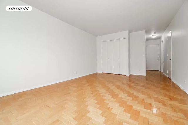 unfurnished bedroom with a closet and light parquet floors