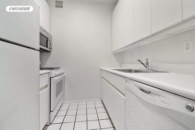 kitchen with white appliances, sink, and white cabinets