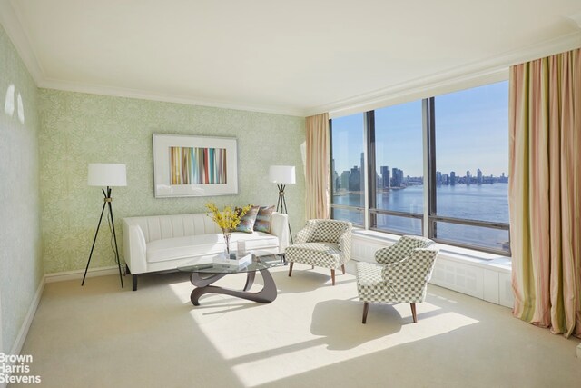 sitting room featuring crown molding, a water view, and light colored carpet