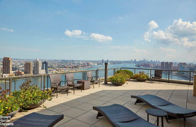 view of patio / terrace with a balcony and a water view