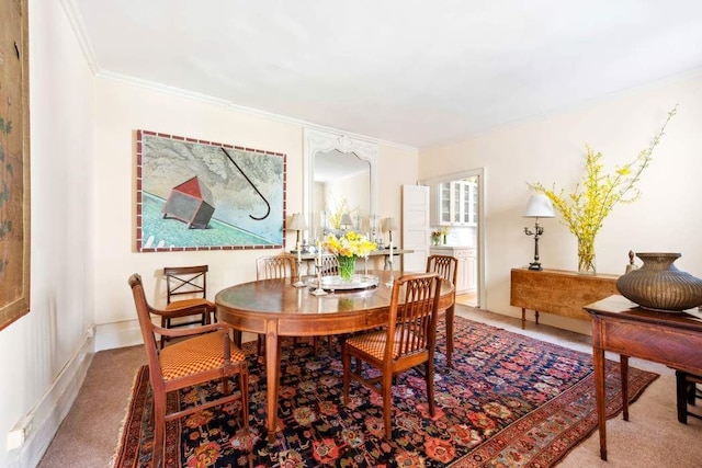 dining space with crown molding and carpet