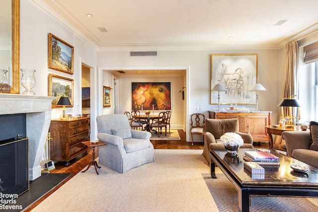 living area with visible vents, crown molding, and a premium fireplace