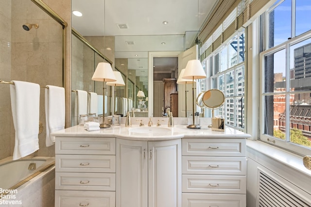 full bathroom with a stall shower, a bathing tub, and vanity