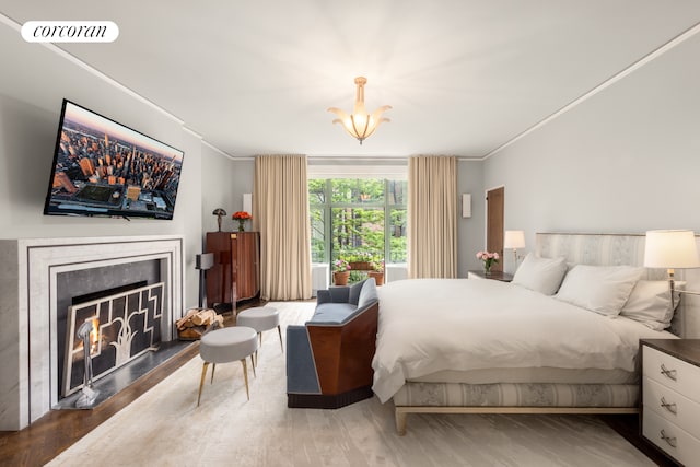 49 E 80th St, New York City, NY 10075 - bedroom with visible vents, a lit fireplace, ornamental molding, and wood finished floors