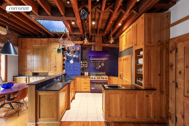 49 E 80th St, New York City, NY 10075 - kitchen with premium appliances, a peninsula, a sink, and dark countertops