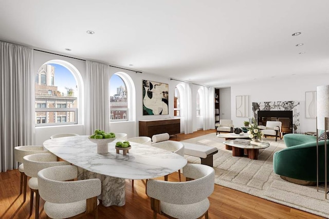 dining room featuring light wood-type flooring and a high end fireplace