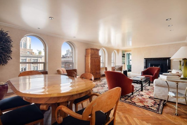 dining area with light parquet floors, ornamental molding, and a fireplace