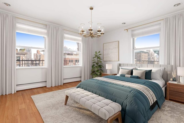 bedroom with light wood-type flooring, baseboard heating, multiple windows, and ornamental molding