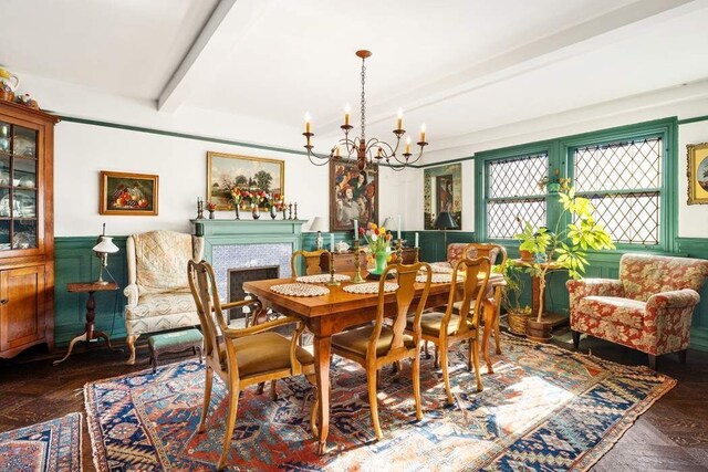 33 W 67th St Unit 6Fe, New York City, NY 10023 - dining area with a chandelier, beamed ceiling, wainscoting, and a fireplace