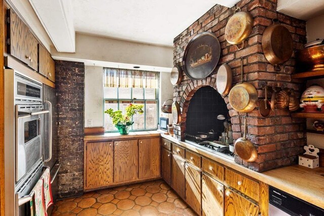 dining room featuring beam ceiling, dark parquet flooring, a tile fireplace, and a chandelier