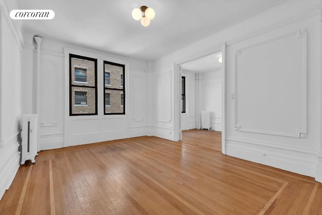 empty room with hardwood / wood-style flooring and radiator