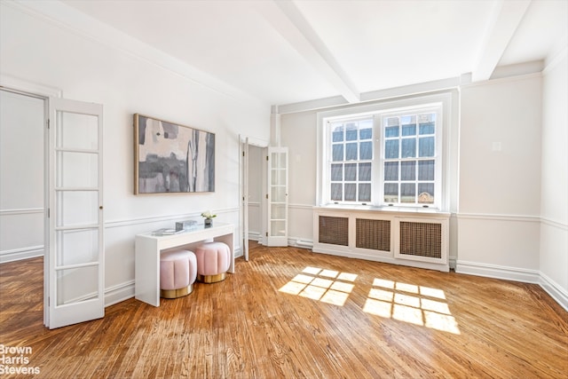 living room with dark hardwood / wood-style flooring, crown molding, and beamed ceiling