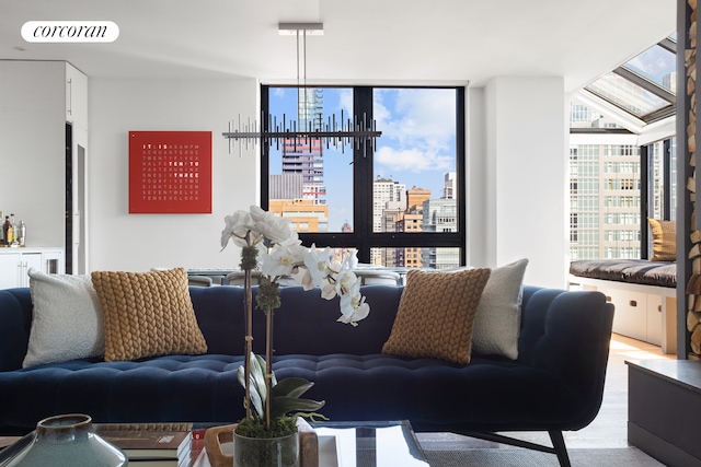 living area featuring a view of city, light wood-type flooring, visible vents, and floor to ceiling windows