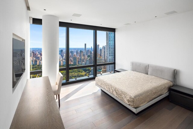 living room featuring hardwood / wood-style flooring, a wall of windows, a healthy amount of sunlight, and a chandelier