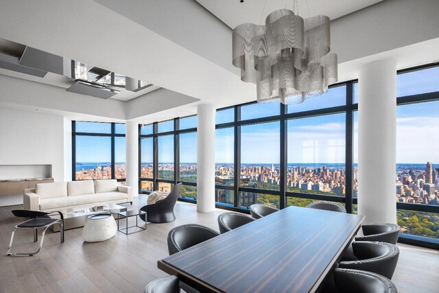 bedroom with expansive windows, hardwood / wood-style floors, and multiple windows