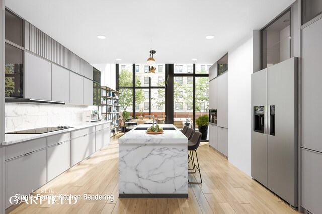 kitchen with stainless steel refrigerator with ice dispenser, floor to ceiling windows, a center island, black electric stovetop, and decorative backsplash