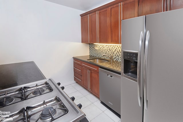 kitchen featuring light tile patterned floors, backsplash, appliances with stainless steel finishes, and sink